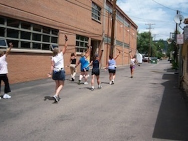 Group exercising outdoors by brick building